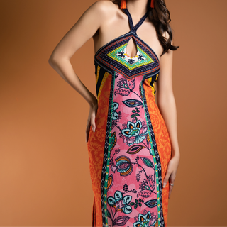 Woman wearing the La Isla Bonita Maxi Dress – colorful halter-neck maxi with keyhole cutout and vibrant floral print in pink, orange, and turquoise tones.